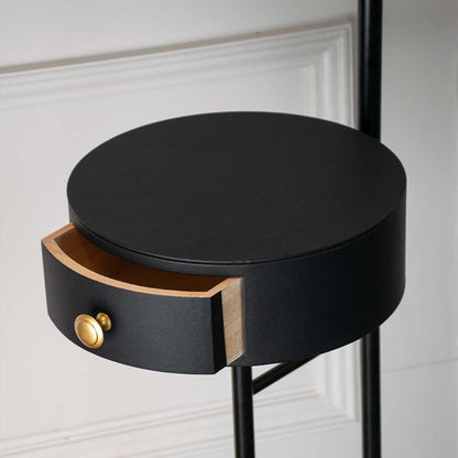 Closeup of modern table lamp head with matte black finish and gold accent highlighting smooth texture and premium lighting design.