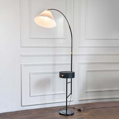 Black metal floor lamp with sculptural white shade and brass stem for modern living room and reading nook decor.