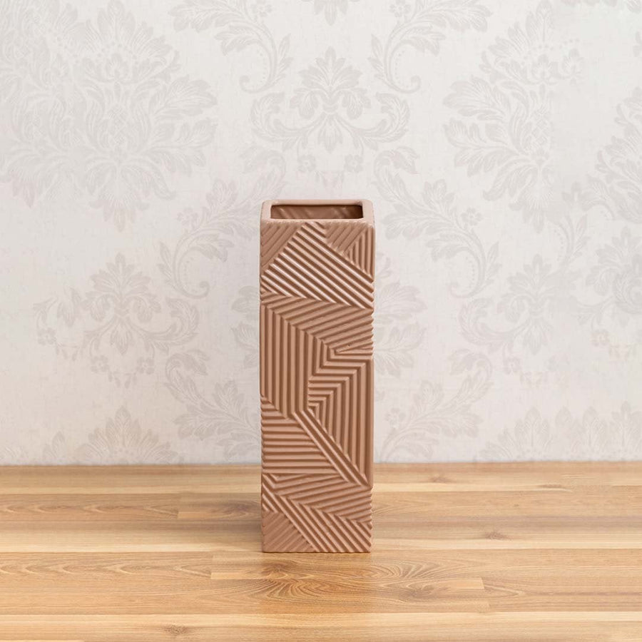 A tall brown geometric vase on a clean white background showing its bold textured pattern and modern sculptural design for home decor.