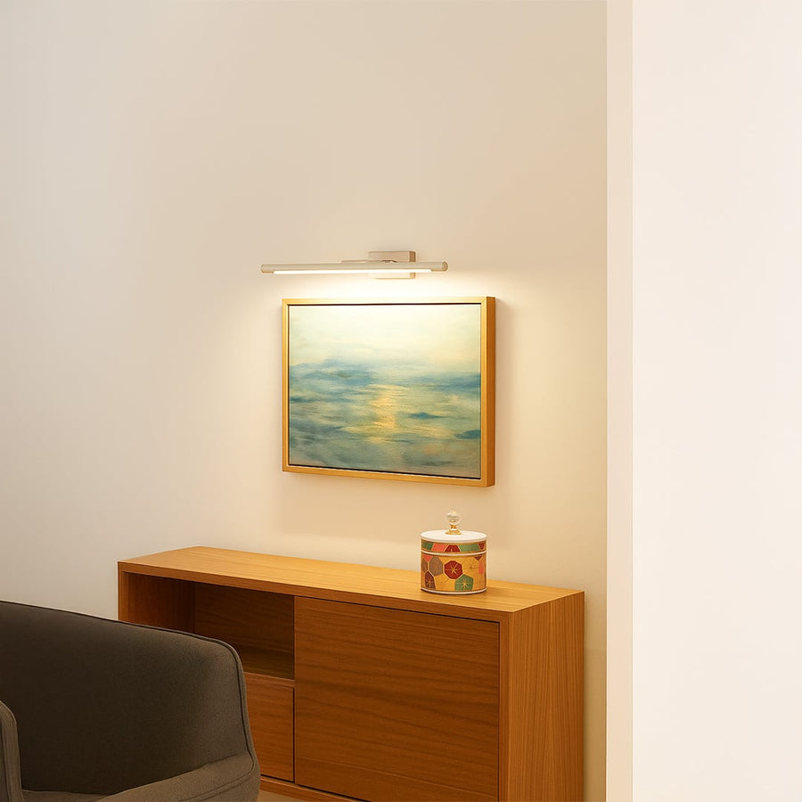 Silver metal picture light styled on a modern wall adding soft warm illumination for elegant living room decor.