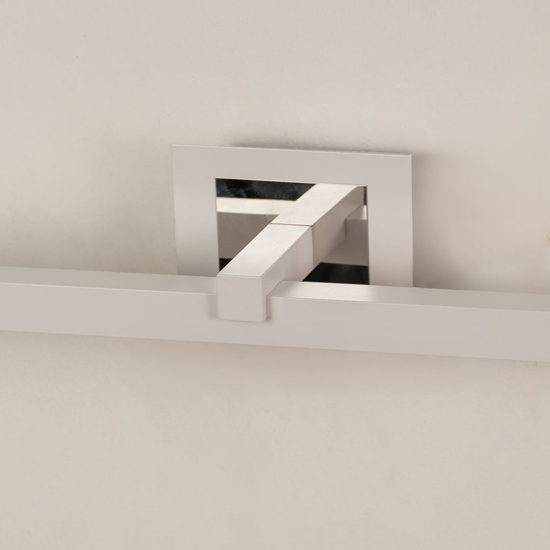 Closeup of silver metal picture light showing smooth finish and detailing with warm focused illumination.