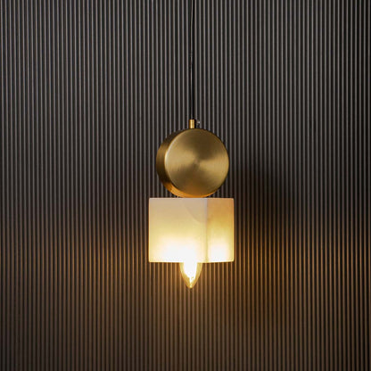 Modern brass pendant lamp with frosted cube glass shade glowing warmly on black background for home interiors.