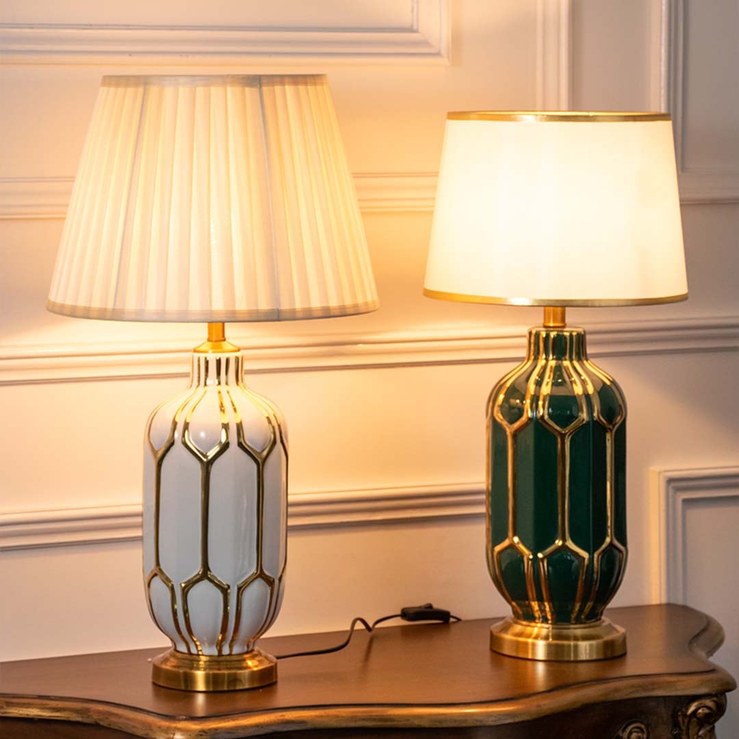 Set of white and green ceramic table lamps with gold accents turned on together adding rich warmth and elegance to classic home interiors.