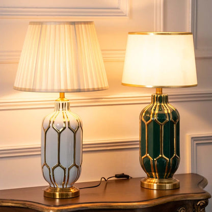 Set of white and green ceramic table lamps with gold accents turned on together adding rich warmth and elegance to classic home interiors.