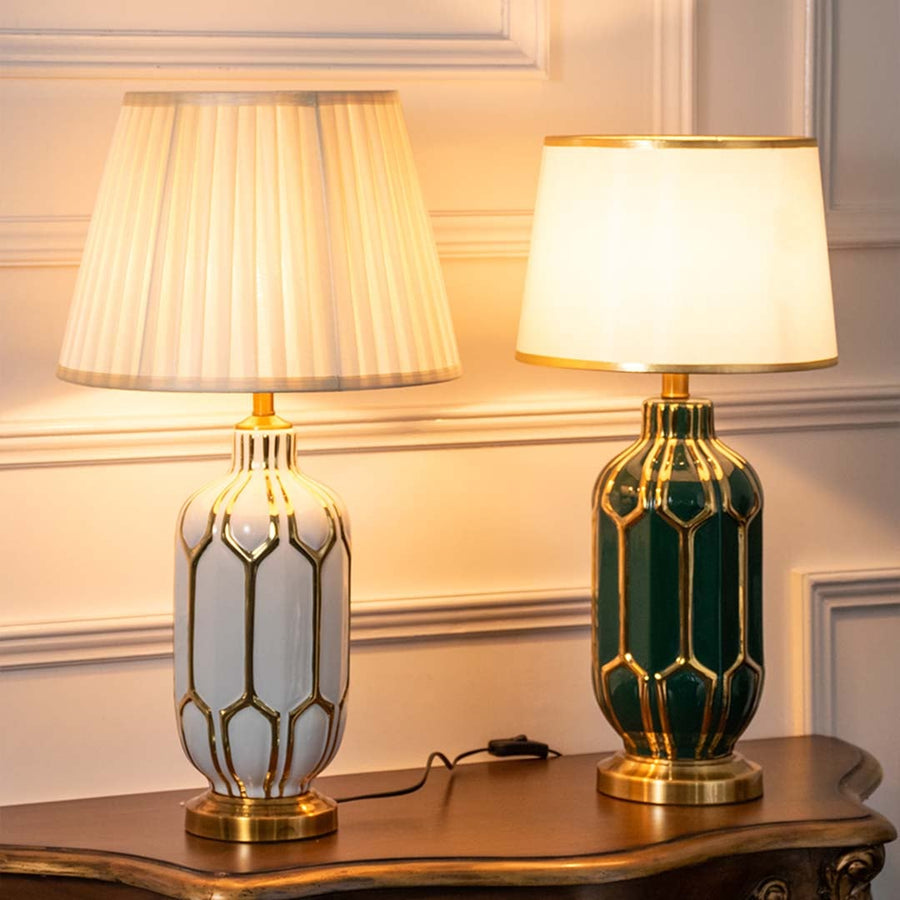 Set of white and green ceramic table lamps with gold accents turned on together adding rich warmth and elegance to classic home interiors.