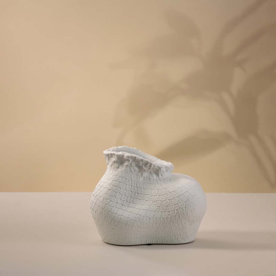 White ceramic decorative vase with organic sculptural form for elegant shelf styling and modern home decor displays.