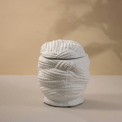 Handcrafted white ceramic vase with a textured pattern glowing gently under light on white background showing artistic craftsmanship.