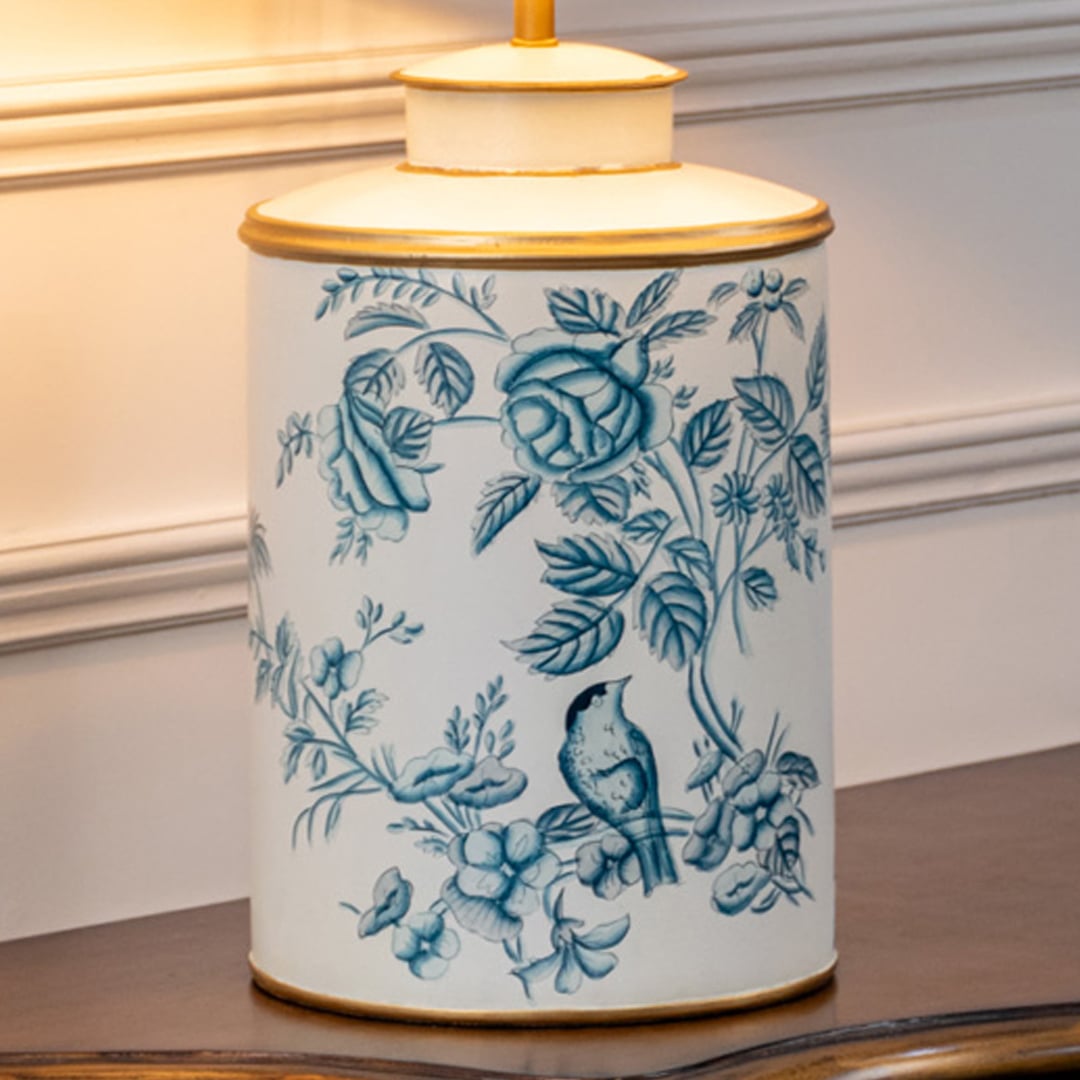 Closeup view of ceramic table lamp base highlighting blue floral bird artwork smooth glaze finish and refined decorative detailing.