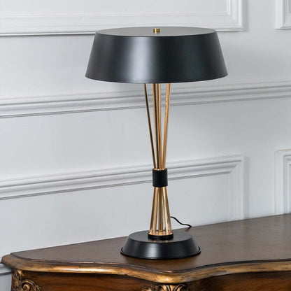 Black and gold metal table lamp with elegant tapered rods and wide shade displayed on a white background perfect for office desks and stylish decor settings.