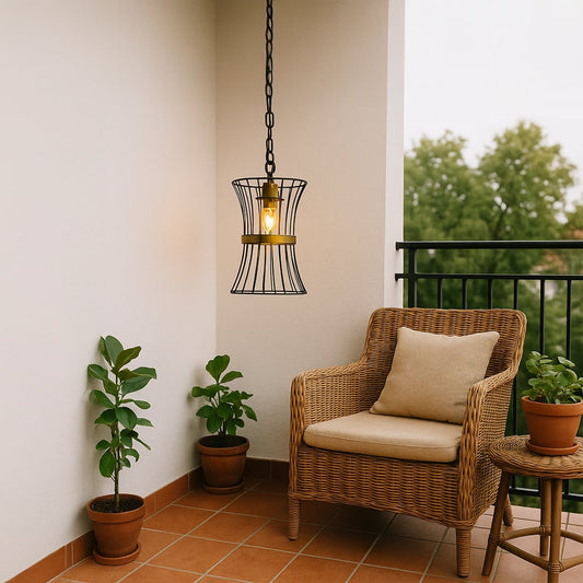 Balcony setup with a black metal pendant light featuring curved cage design glowing warmly beside a wicker chair potted plants and soft neutral decor.