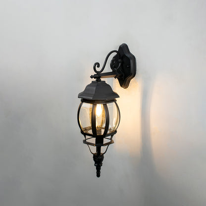 Black metal outdoor wall light on white background with warm ambient glow for classic exterior lighting decor.