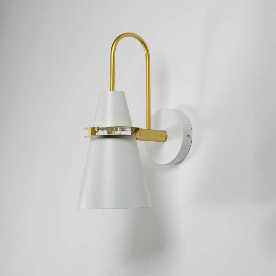 Modern wall light on white background with light off displaying matte white cone shade and brass accent.