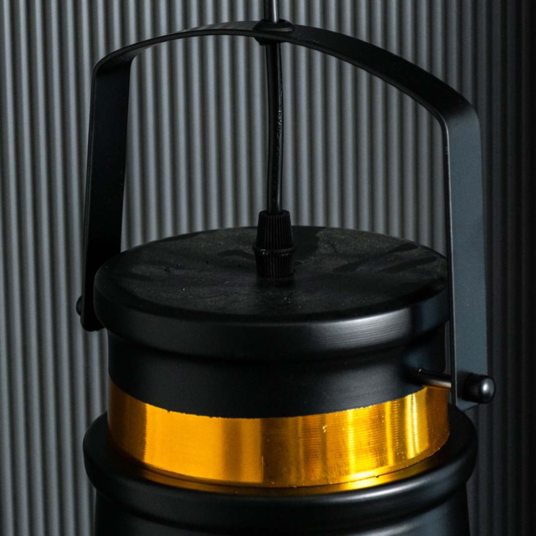 Closeup view of the black and gold metal pendant light showing its top handle and gold band with a refined industrial design.