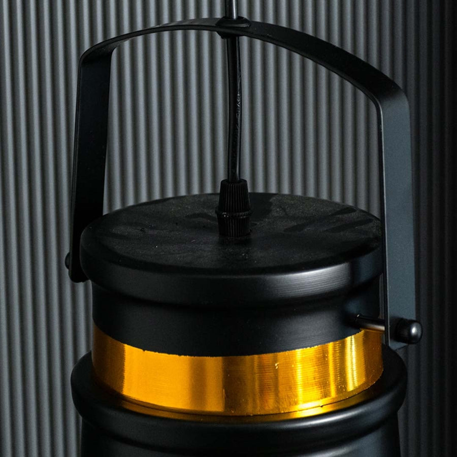 Closeup view of the black and gold metal pendant light showing its top handle and gold band with a refined industrial design.