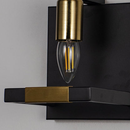 Black and gold wall light with metal frame and exposed bulb shown off on white background for modern interior wall decor.