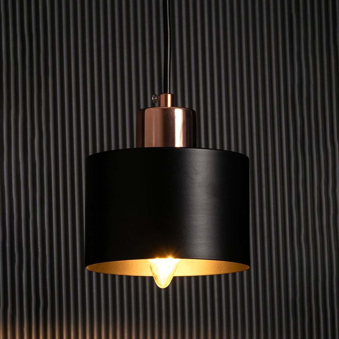 Amber glass globe wall light glowing warmly on a dark background showcasing its soft ambient lighting effect and elegant golden metal frame.
