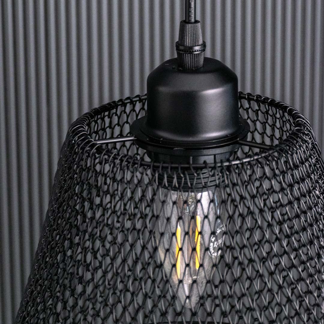 Detailed view of the black mesh pendant light showing the woven metal pattern and warm bulb glow for a textured modern industrial look.