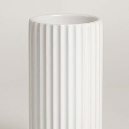 Closeup of white ceramic vase with vertical ribbed texture showcasing premium craftsmanship and modern decor styling.