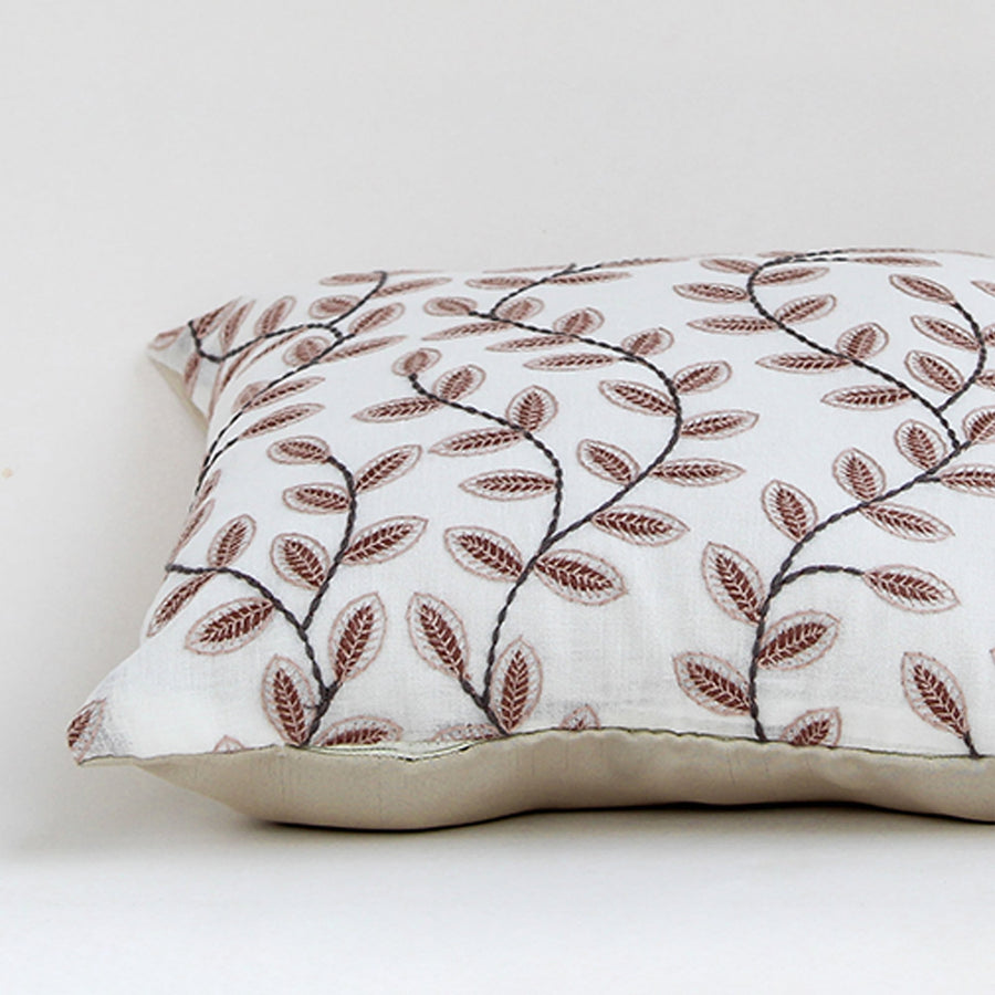 Closeup of cotton cushion embroidery showing detailed brown leaf stitching and soft fabric texture ideal for warm and elegant home decor styling.