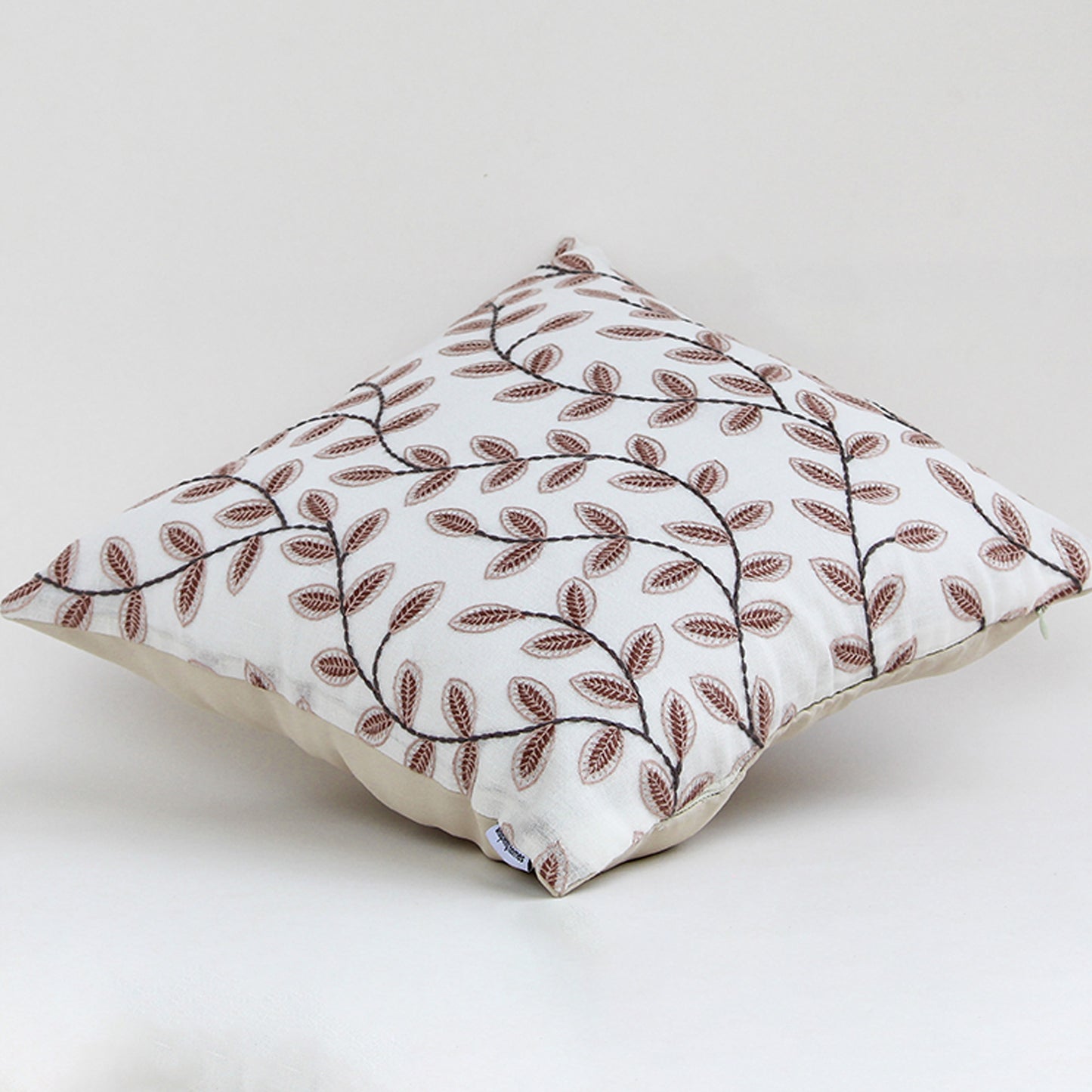 Cotton cushion with brown embroidered leaf pattern displayed on a white background highlighting detailed stitching and soft fabric texture for home styling.