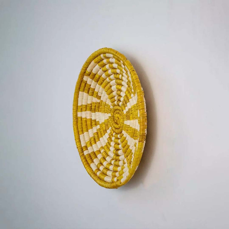 Side profile of yellow beige bamboo wall plate highlighting detailed weaving texture and natural craftsmanship.