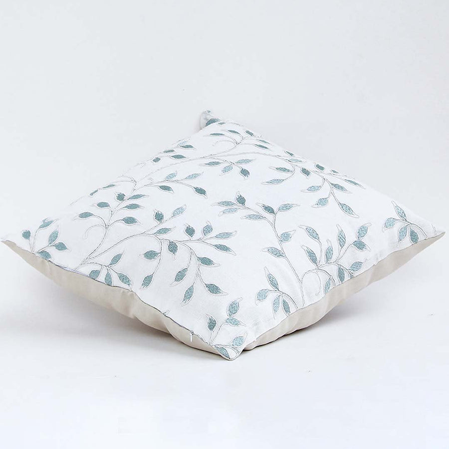 White cotton cushion cover with grey botanical pattern shown at an angle adding a subtle nature inspired décor accent with a breathable gentle and skin friendly fabric feel.
