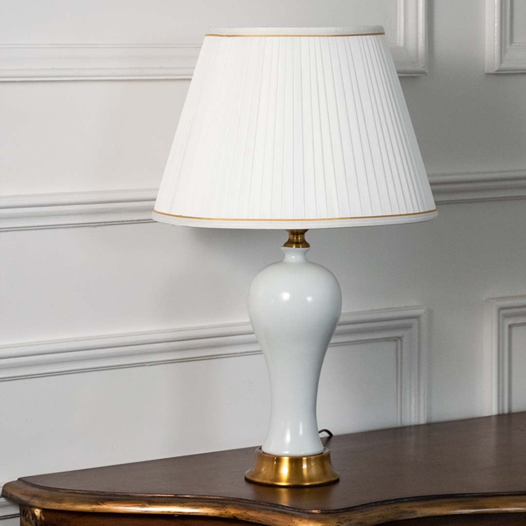 White ceramic table lamp with gold base and pleated shade displayed on a white background perfect for modern home decor and elegant side table styling.