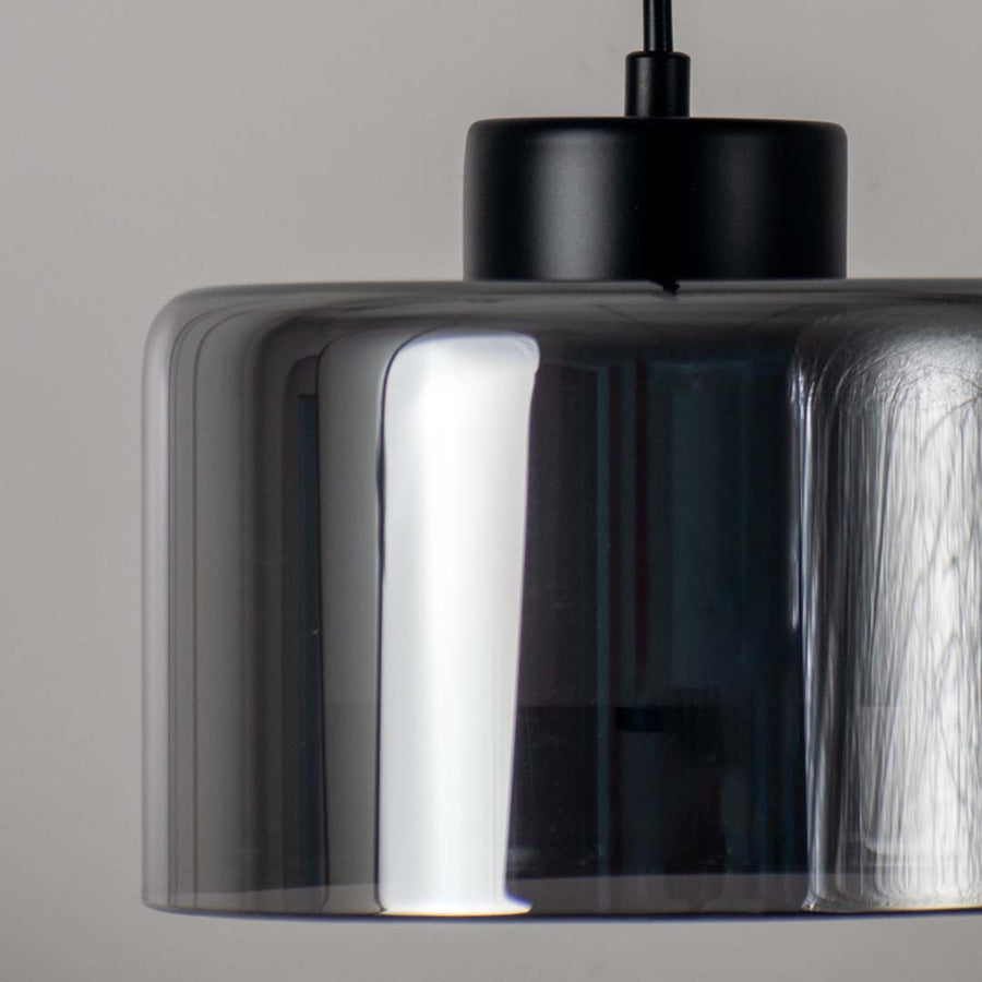 Closeup of smoked glass pendant light with black finish elegant modern ceiling lamp for stylish home decor and interior lighting.