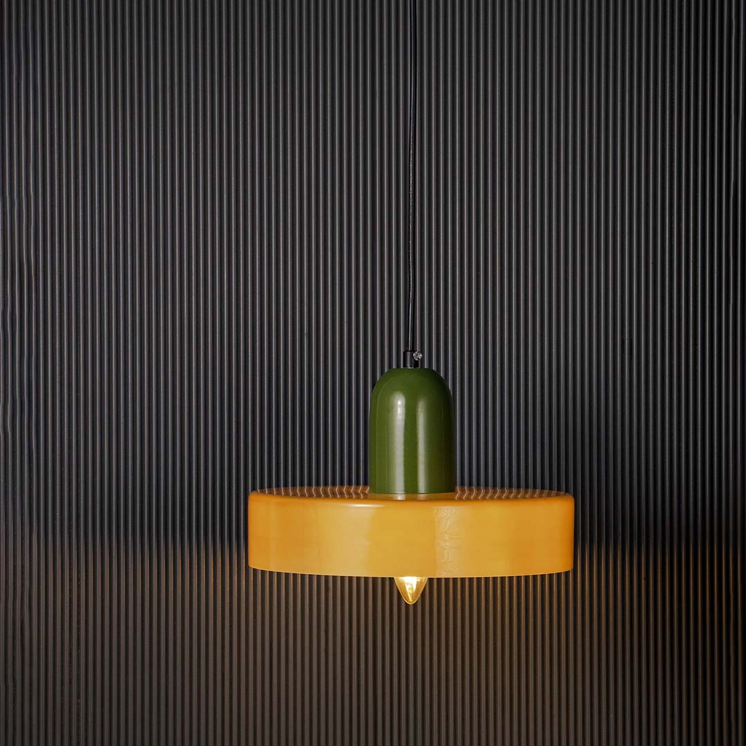 Green and brown two tone pendant ceiling light with height 25 cm and width 22 cm shown clearly against plain off white wall.