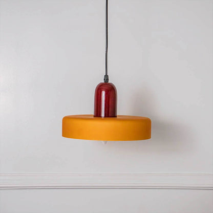 Contemporary mustard yellow and red round pendant ceiling light presented on minimal off white background for stylish interiors.
