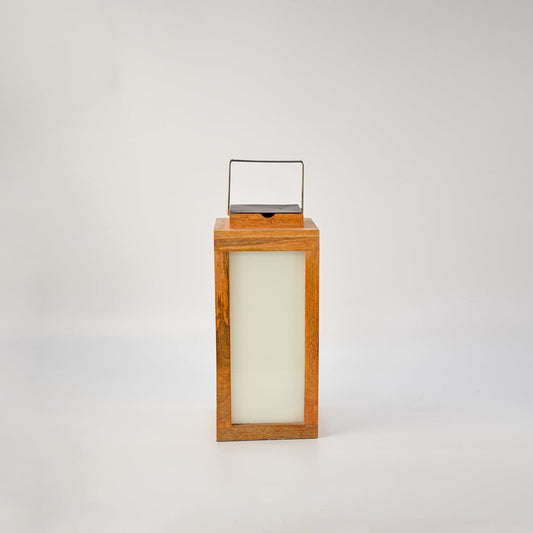 Wood lantern glowing on a white background showing its frosted glass panel illumination and premium wood craftsmanship — a modern decorative lighting piece.
