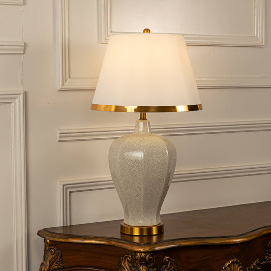 White textured ceramic table lamp with fabric shade and gold accents offering refined traditional decor lighting indoors.