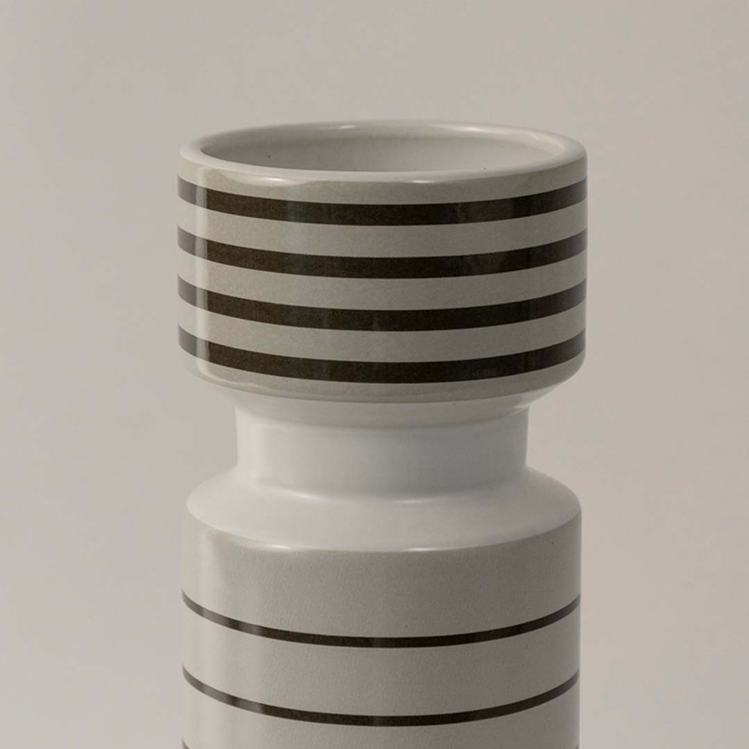 Closeup of tall ceramic vase with horizontal black stripes highlighting glossy finish and elegant design for home styling.