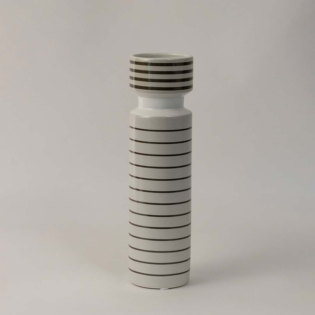 Side angle view of striped ceramic vase with glossy white finish and black horizontal lines styled for modern interior decor.