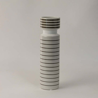 Side angle view of striped ceramic vase with glossy white finish and black horizontal lines styled for modern interior decor.