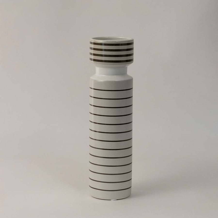 Side angle view of striped ceramic vase with glossy white finish and black horizontal lines styled for modern interior decor.