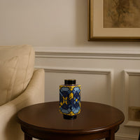 Lifestyle image of blue and yellow ceramic jar vase with geometric design placed on wooden side table in living room