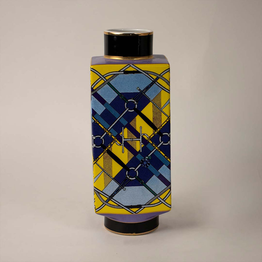 White background image ceramic decorative jar vase with geometric blue and yellow design and black lid perfect decor.
