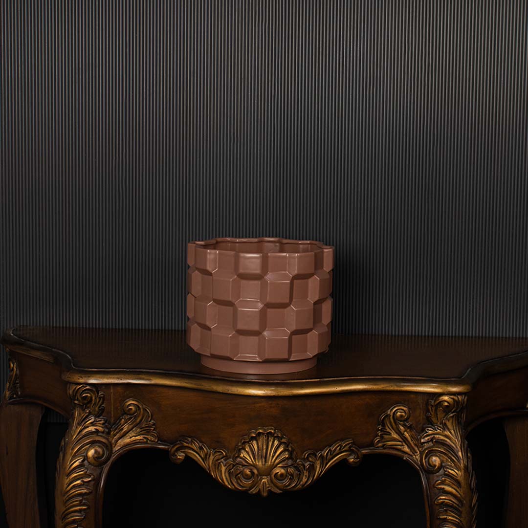 Brown geometric ceramic planter shown on a dark background highlighting its textured pattern and glossy finish for elegant decor styling.