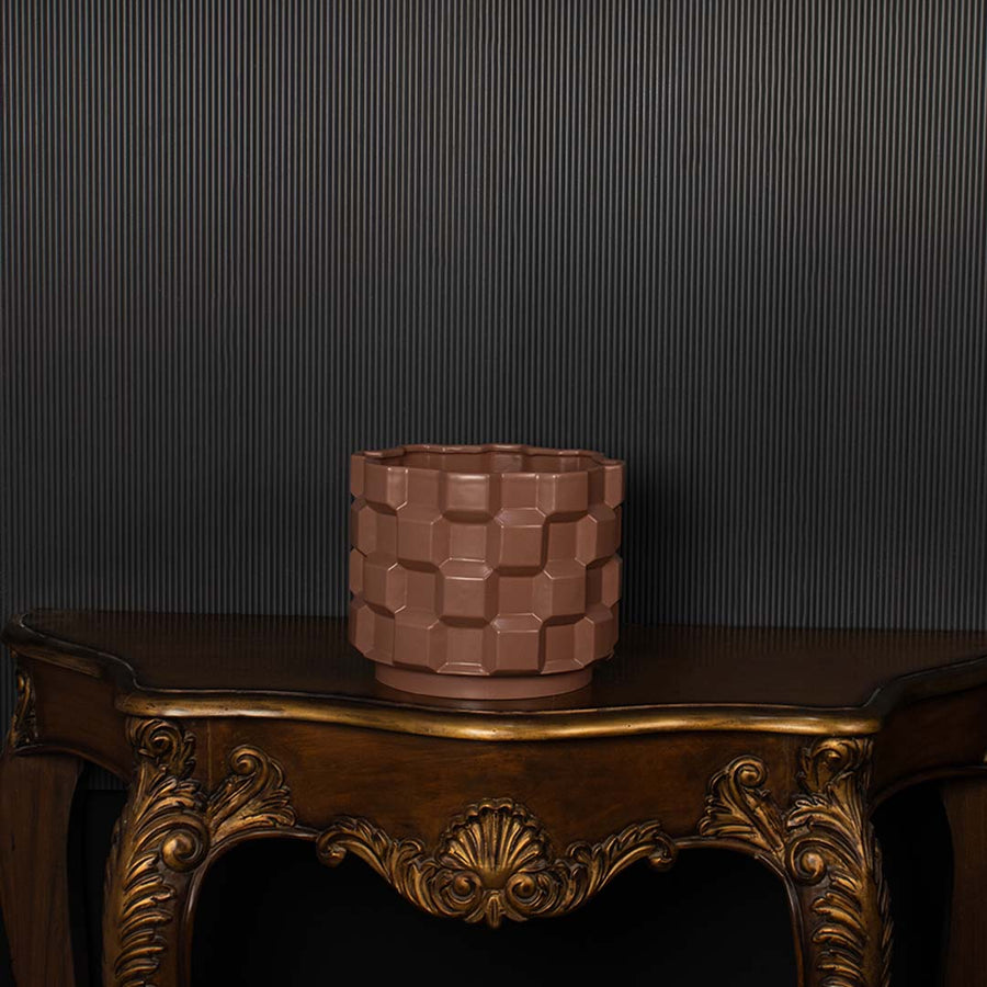 Brown geometric ceramic planter shown on a dark background highlighting its textured pattern and glossy finish for elegant decor styling.