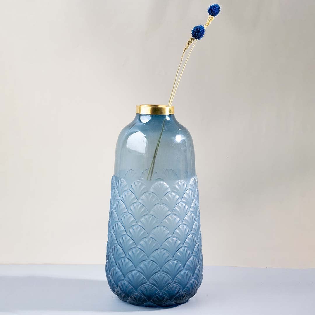 Tall blue glass vase with scallop embossed texture and gold rim shown against white background elegant home decor glass vase.