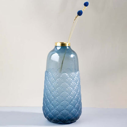 Tall blue glass vase with scallop embossed texture and gold rim shown against white background elegant home decor glass vase.