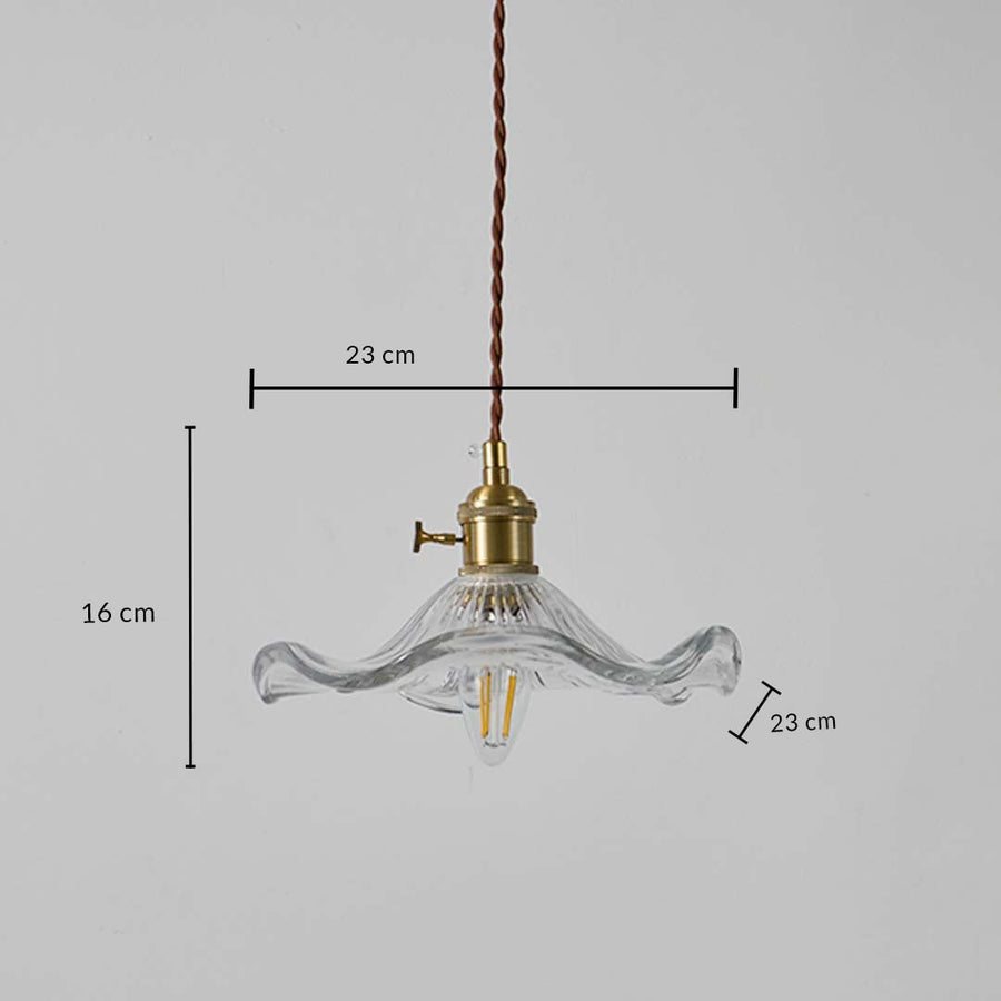 Clear wavy glass pendant light with brass top shown with 23 cm width and 16 cm height dimension for decor detailing.