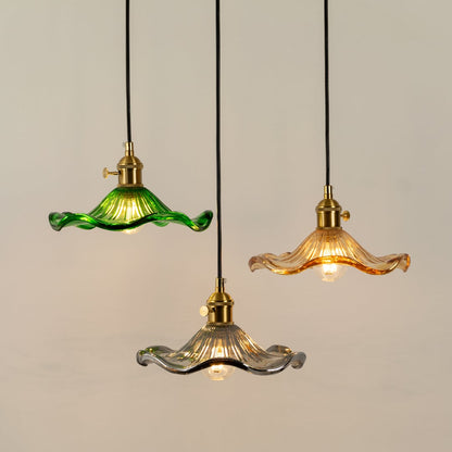 Green amber and clear glass pendant lights illuminated to showcase artistic modern ceiling lighting design appeal.