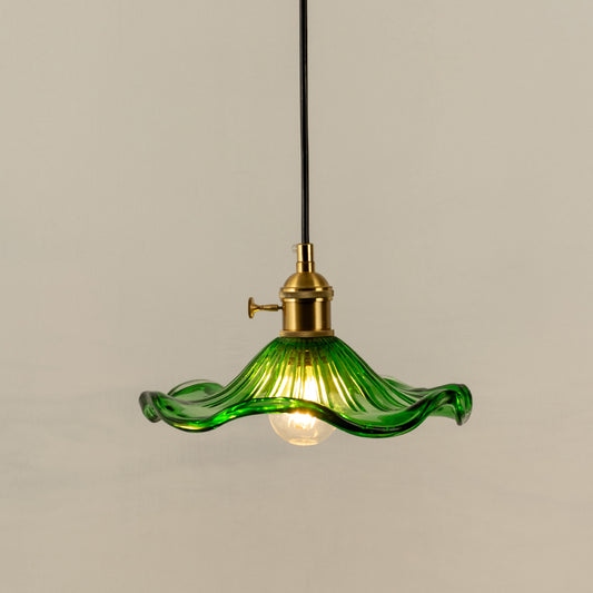 Pendant light with green glass shade and gold metal holder perfect for modern kitchen or dining space decor on clean background.
