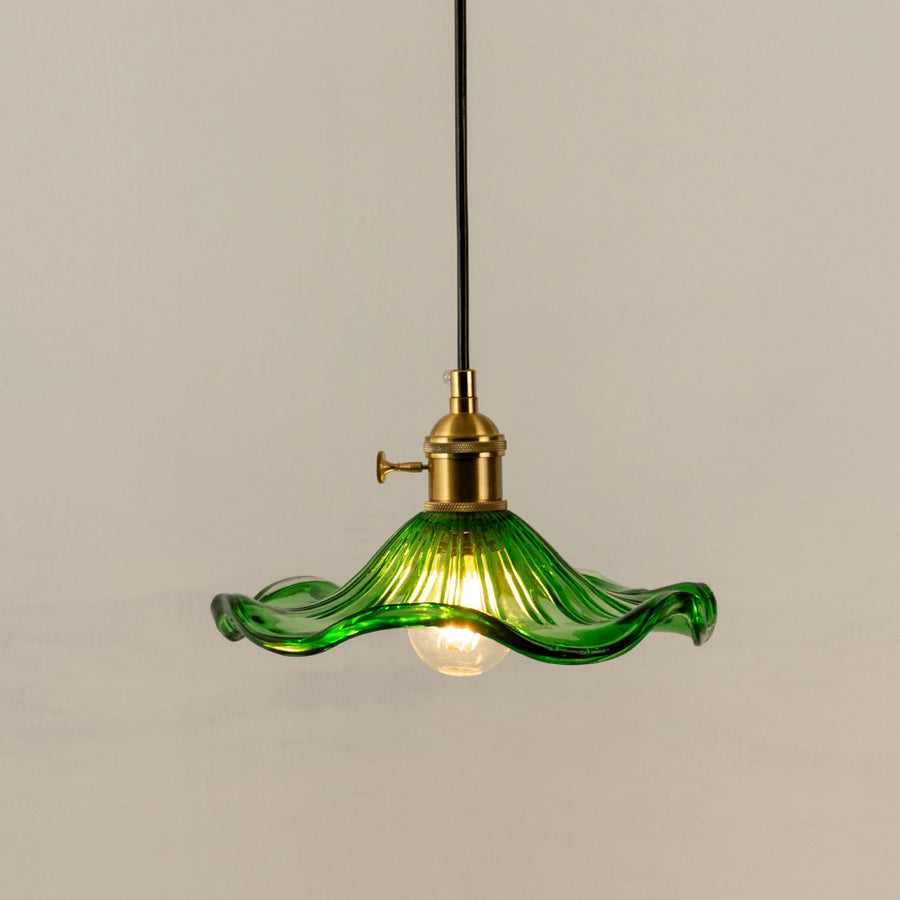 Pendant light with green glass shade and gold metal holder perfect for modern kitchen or dining space decor on clean background.