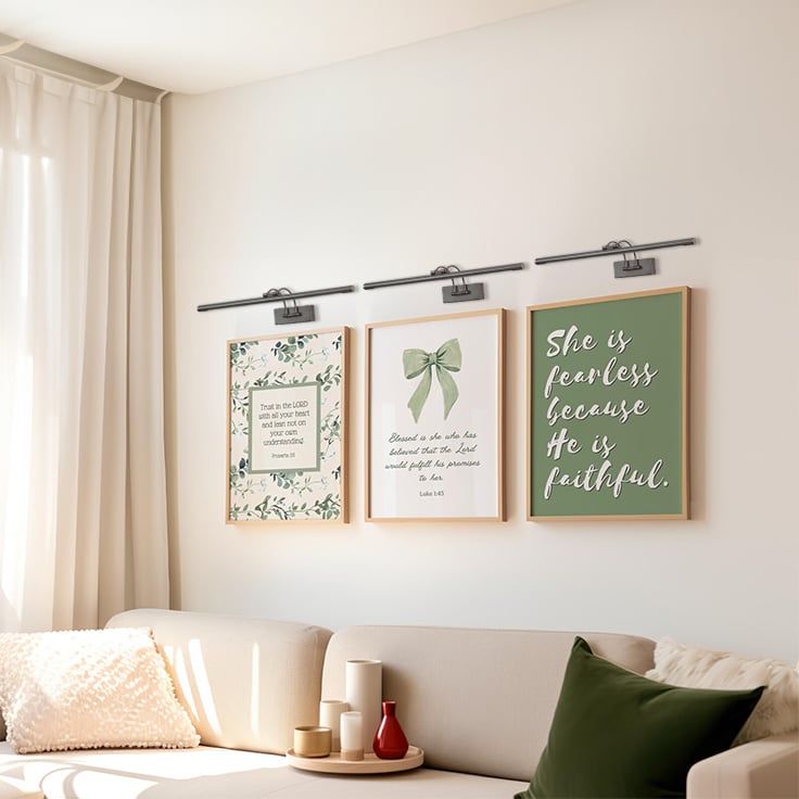 Grouped lifestyle view of modern metal picture lights enhancing wall art and home decor styling.