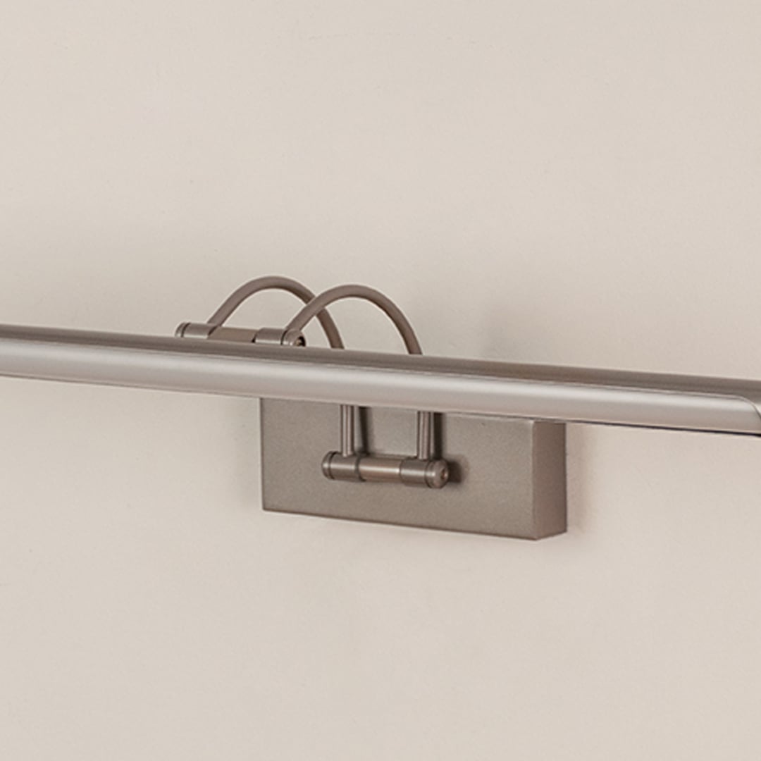 Closeup of sleek silver picture light showing its smooth metal finish and adjustable arm for precise wall illumination.