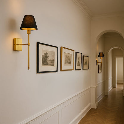Gold metal wall sconce with tall black fabric shade styled in a modern room adding warm soft glow for elegant wall decor.