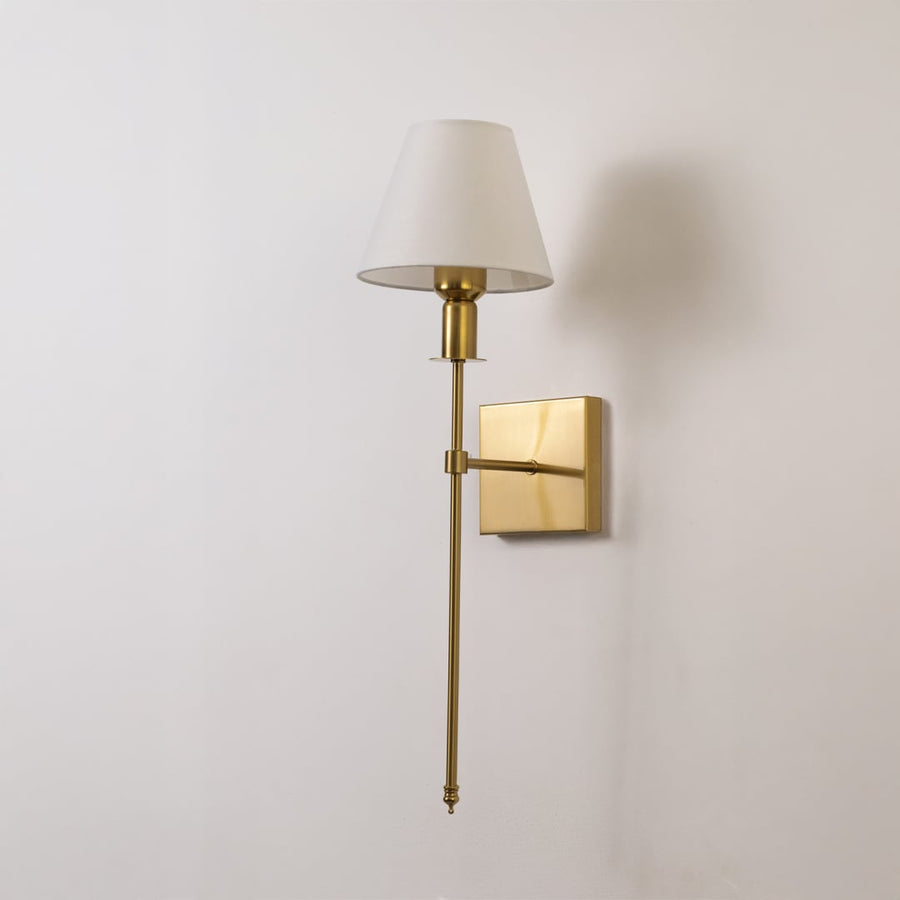 Gold metal wall sconce with white fabric shade shown switched off on white background for minimal elegant wall decor.